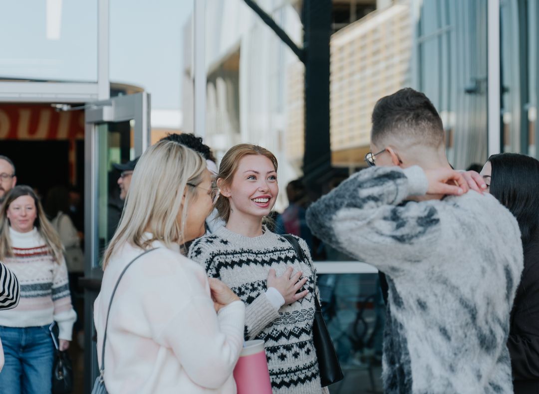 Smiling women at the Movement Church entrance